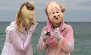 Zwei Maskenfiguren mit Vogelmasken am Strand in der Bretagne
